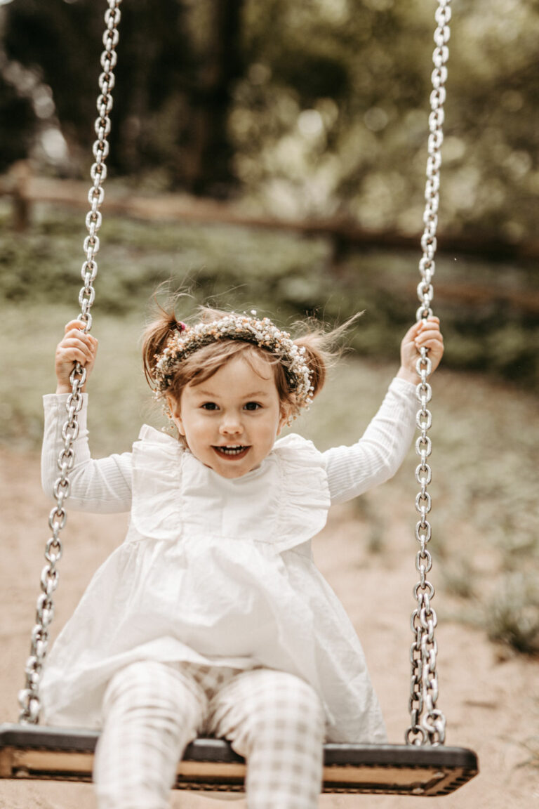 Familienfotografie - Mutter und Vater spazieren mit ihrer Tochter durch einem schönen Schlossgarten von Schloss Wiligrad bei Schwerin im Frühling.