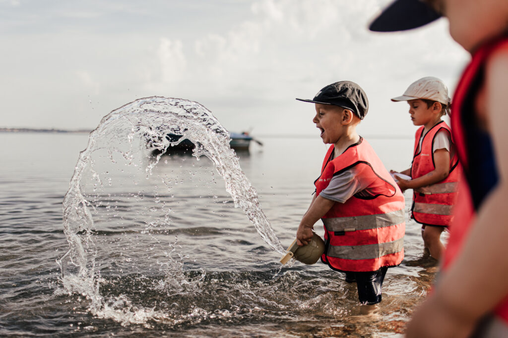 Kinder machen einen Ausflug an den Strand mit ihrer Tagesmutter. Die Kinder haben Spaß. 