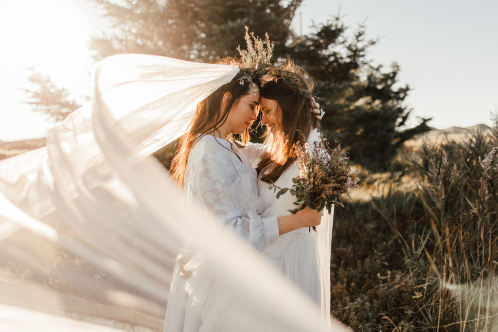 Zwei dunkelhaarige Bräute heiraten in der Landschaft von Hvide Sande bei untergehender Sonne