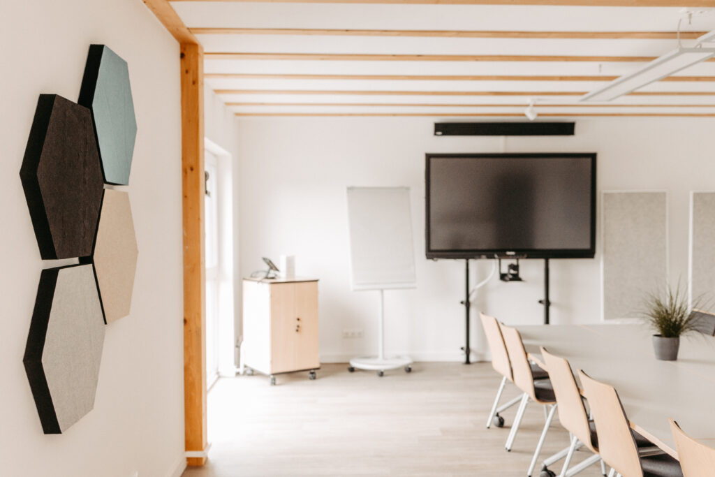 Helle Räumlichkeiten der Weiterbildung mit Stühlen, Tischen und Fenstern sind zu sehen. 