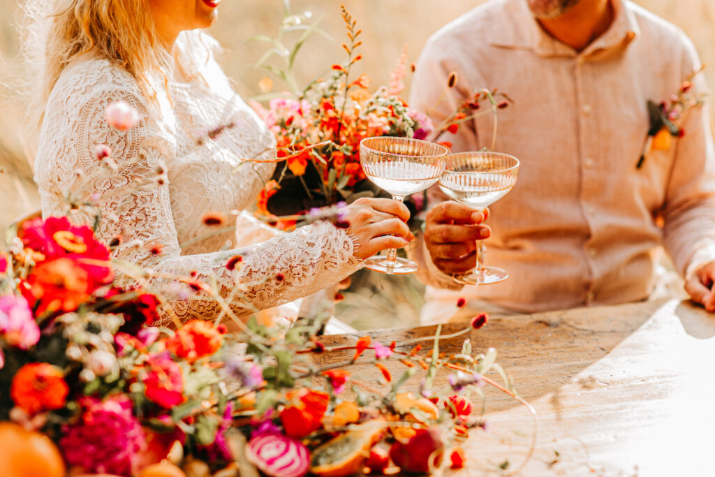 Ein Paar sitzt an der reich gedeckten Hochzeitstafel.