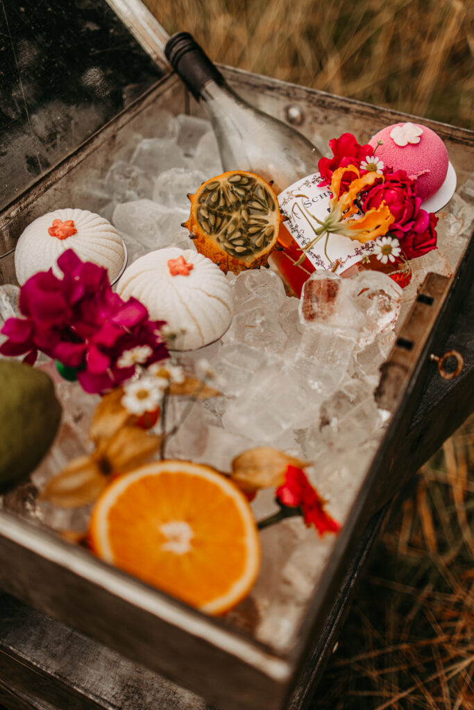 Kleine Kuchen, dekoriert mit Blumen und einer Flasche Sekt.